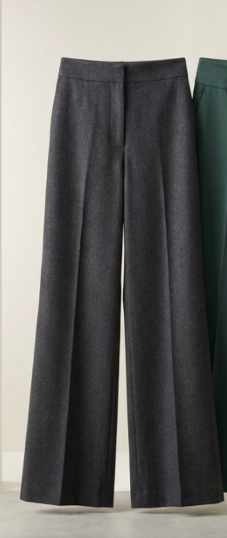 A pair of charcoal wide-leg pleated trousers on a pedestal.