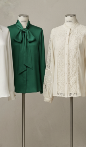 An emerald green tie-neck blouse displayed on a dress form.